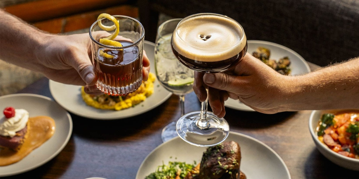 Diners toasting their drinks over a table full of food